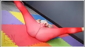 Regina Noir In A Woman In Yoga Leotards Practices Yoga In The Gym. Transparent Red Leotard Yoga