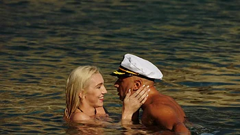 A girl with big boobs is having fun on the beach with her boyfriend.